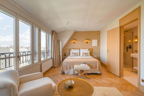 a hotel room with a bed and a balcony at Hôtel Madison in Paris