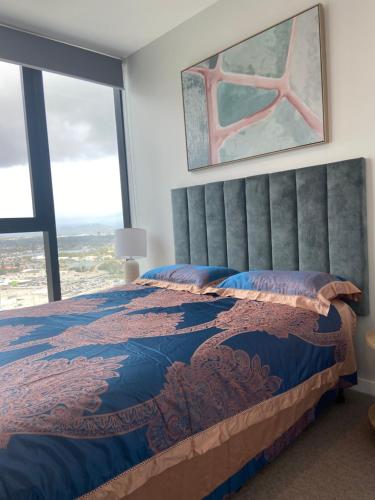 a bedroom with a large bed with a large window at Luxury Casino Apartment in Broadbeach Island in Gold Coast