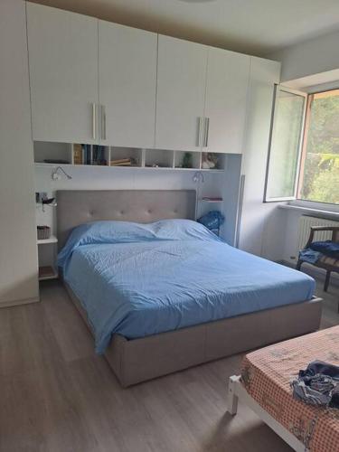 een slaapkamer met een bed met blauwe lakens en witte kasten bij Appartamento Varazze in Varazze