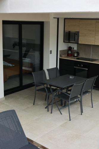 - une table et des chaises dans une pièce avec cuisine dans l'établissement Marina Di Fautea, à Olmucciu