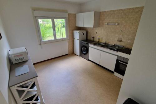 une petite cuisine avec un évier et un réfrigérateur dans l'établissement Appt cosy St Laurent - Chambord, à Saint-Laurent-Nouan