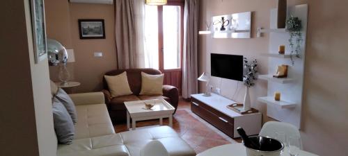 a living room with a couch and a tv at La Colina Golf & Beach in Huelva