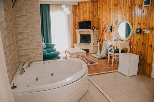 ein Badezimmer mit Badewanne und ein Wohnzimmer in der Unterkunft Ayisigi Hotel in Agva