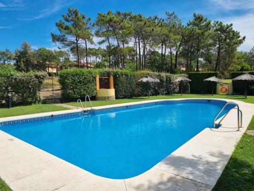 uma grande piscina azul num quintal em Laguna Golf, Hoyo 17, Islantilla em Islantilla