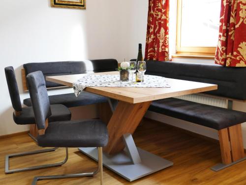 a table and two chairs with wine glasses on it at Landhaus Sabine in Zellberg