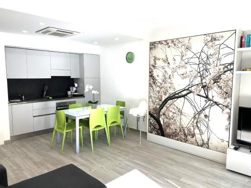 Green House Varazze في فاراتسي: مطبخ وغرفة طعام مع لوحة كبيرة على الحائط