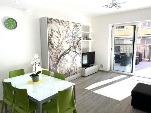 een eetkamer met een witte tafel en groene stoelen bij Green House Varazze in Varazze