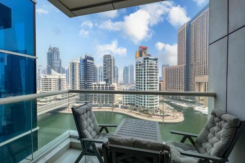 a balcony with two chairs and a view of the city at FAM Living - Continental Tower - 2B with Spectacular Marina Views in Dubai