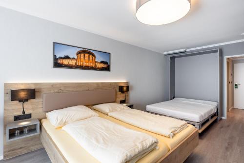 a bedroom with two beds and a tv on the wall at Hotel Restaurant Bismarckturm in Aachen