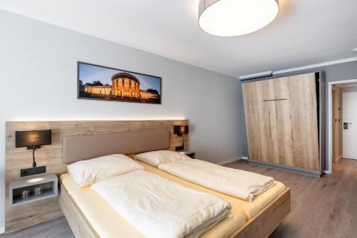 a bedroom with two beds and a tv on the wall at Hotel Restaurant Bismarckturm in Aachen
