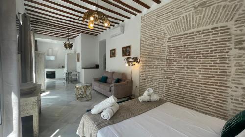 un soggiorno con un muro di mattoni e un letto di Adriano by Global a Siviglia