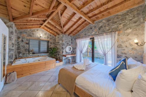 una camera da letto con un letto e una vasca da bagno di VILLAS KAYAKOY 2 OLUDENIZ/FETHIYE a Fethiye