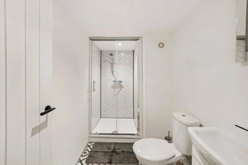 a white bathroom with a toilet and a shower at Sleek and Stylish Yorkshire Gem - Sleeps 4 in Castleford