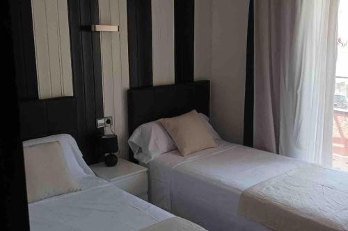 a bedroom with two beds and a window at Apartament a L’Estartit x 4 in Torroella de Montgrí