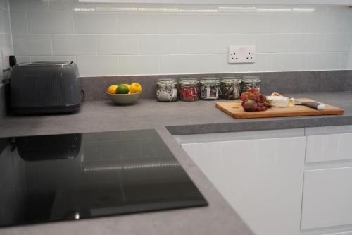 a kitchen counter with a cutting board with fruit on it at Summertown Oxford- Entire 4 bedroom home, sleeps up to 10- 10 mins to city centre in Oxford