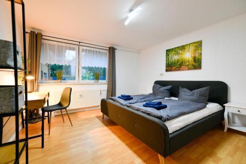 1 dormitorio con cama, mesa y escritorio en Großes Spree Apartment, 3 Schlafzimmer bis 10 Personen, 4x KfZ Parkplatz, Terrasse, Waschtrockner, Wlan, Netflix, en Cottbus