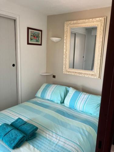 une chambre avec un lit avec des draps bleus et un miroir dans l'établissement Richelieu 4, piscine, parking, port & resto a pied, au Cap d'Agde