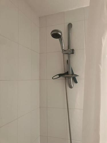 une douche avec un pommeau sur un mur de carrelage blanc dans l'établissement Richelieu 4, piscine, parking, port & resto a pied, au Cap d'Agde