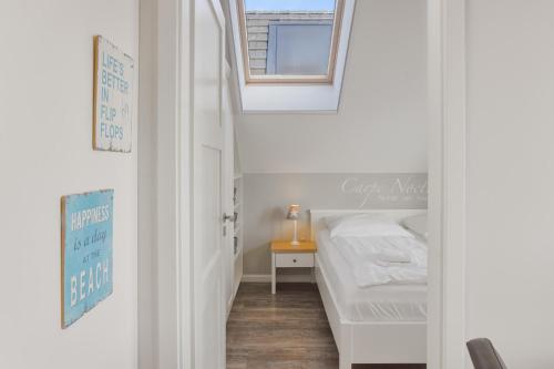 ein kleines Schlafzimmer mit einem Bett und einem Fenster in der Unterkunft Yachthafenblick in Heiligenhafen