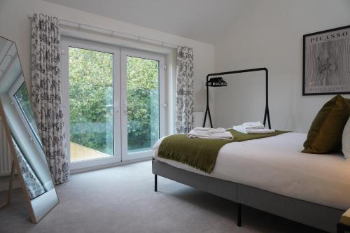 a bedroom with a bed and a large window at Summertown Oxford- Entire 4 bedroom home, sleeps up to 10- 10 mins to city centre in Oxford