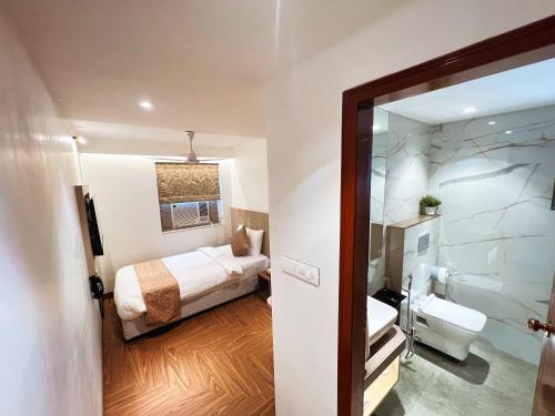a bathroom with a bed and a toilet in a room at White House by Maxxvalue Service Apartments Bandra in Mumbai