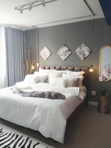 ヨハネスブルグにある@Derricks Luxury Apartmentsのベッドルーム(白い大型ベッド、白い枕付)