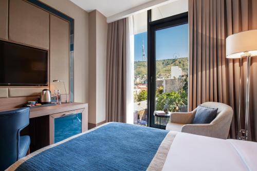 a hotel room with a bed and a large window at Tbilisi Philharmonic Hotel by Mercure in Tbilisi City
