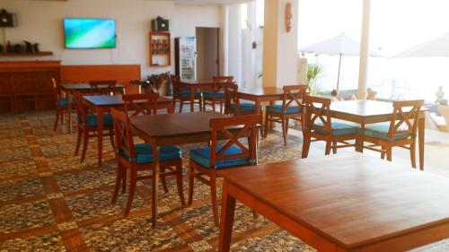 uma sala de jantar com mesas e cadeiras de madeira em Villa Aryaguna em Senggigi