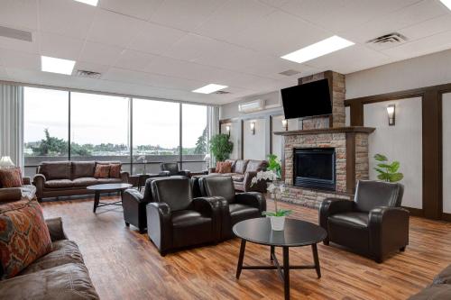 a living room with leather furniture and a fireplace at Days Inn by Wyndham Calgary South in Calgary