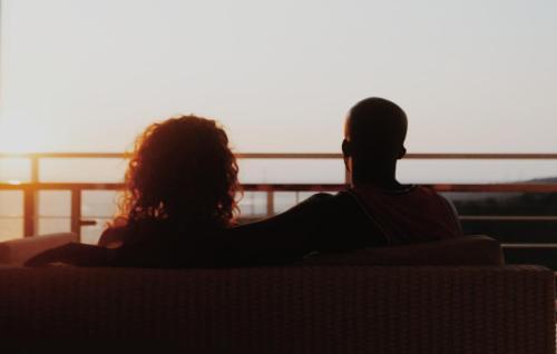 a couple sitting on a couch watching the sunset at Villa Aryaguna in Senggigi 