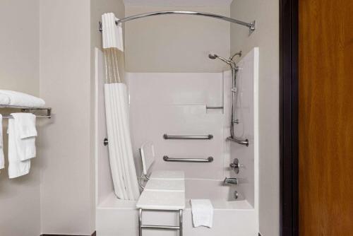 a white bathroom with a shower and a sink at Baymont by Wyndham Waterloo in Waterloo