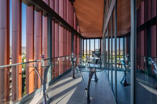 a balcony with tables and windows on a building at Tbilisi Philharmonic Hotel by Mercure in Tbilisi City