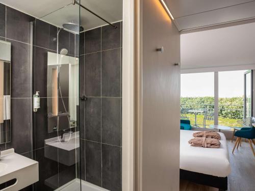 y baño con cama y ducha acristalada. en ibis Thalassa Le Touquet, en Le Touquet-Paris-Plage