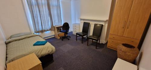 a bedroom with a bed and a desk and a chair at Grove Lane in Ipswich