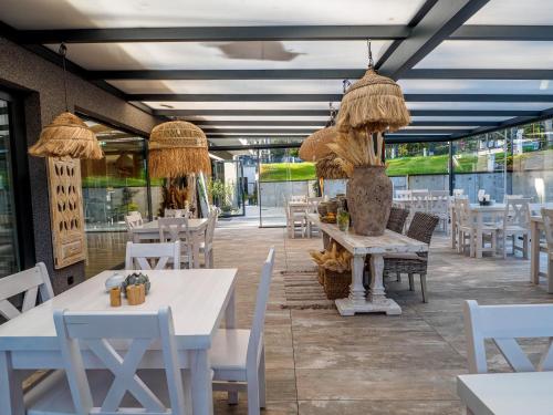 restauracja z białymi stołami i białymi krzesłami w obiekcie Natura Mierzei 30 w mieście Krynica Morska