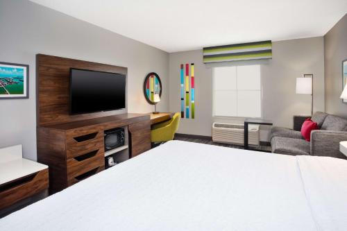 a hotel room with a bed and a flat screen tv at Hampton Inn & Suites Cape Coral / Fort Myers in Cape Coral