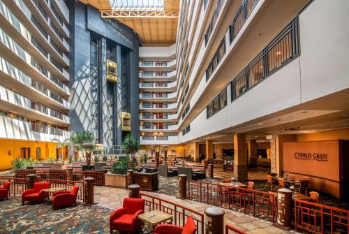 a lobby of a hotel with red chairs and tables at Embassy Suites by Hilton Albuquerque in Albuquerque