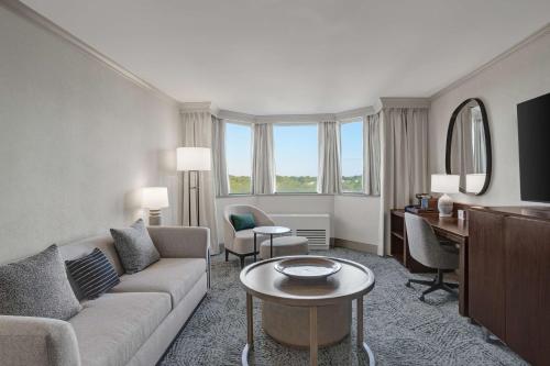 a living room with a couch and a table and a desk at Hilton Arlington National Landing in Arlington