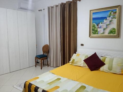 una camera con un letto e una sedia di Guest room near historical center a Vlorë