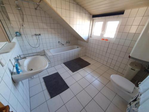 La salle de bains est pourvue d'un lavabo, d'une baignoire et de toilettes. dans l'établissement Ferienwohnung, à Rheinstetten