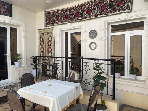 uma sala de jantar com uma mesa branca e cadeiras em Isfandiyor Hotel em Samarkand