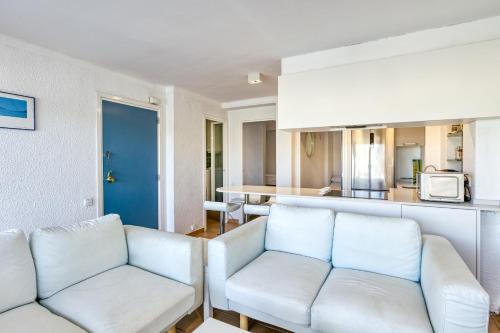a living room with two white couches and a kitchen at 1a Linea mar port Llafranch in Llafranc