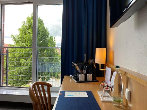 a room with a desk and a window with a view at Hotel Stadthafen Stade in Stade