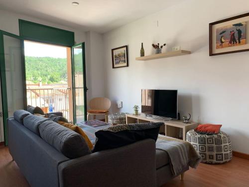 a living room with a couch and a television at ApartaMonti Dúplex in Montesquíu