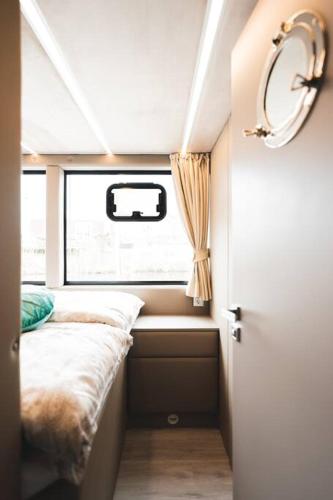 a small room with a bed and a window at Deine schwimmende Auszeit auf dem Wasser - Festlieger Hausboot Tortuga in Dömitz