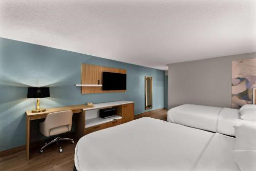 a hotel room with a bed and a desk with a computer at Wyndham Garden Ankeny in Ankeny