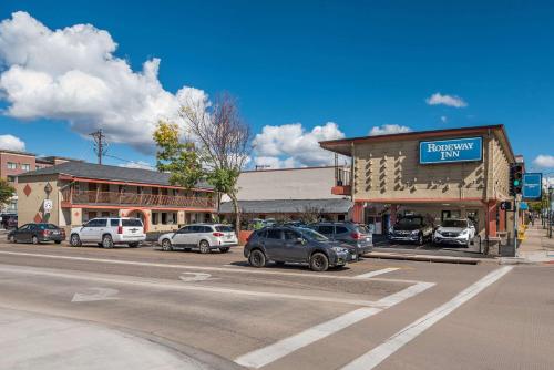 a parking lot with cars parked in front of a building at Rodeway Inn Flagstaff-Downtown in Flagstaff