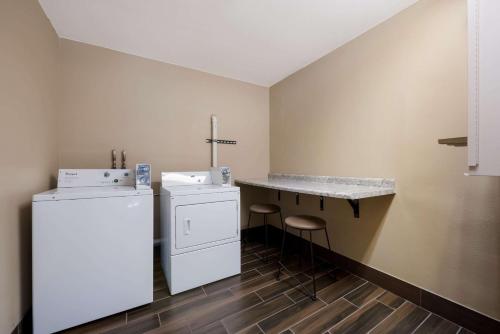 a kitchen with a refrigerator and a counter with stools at Comfort Inn Onalaska - La Crosse Area in Onalaska