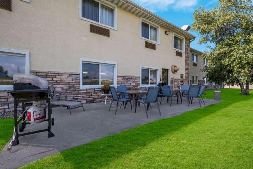 a patio with chairs and a grill in front of a building at Comfort Inn Onalaska - La Crosse Area in Onalaska