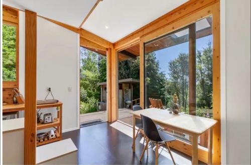 - une cuisine et une salle à manger avec une table et des chaises dans l'établissement Fantail’s Nest in the forest, à Takaka